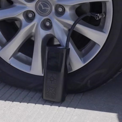 ProPump cordless inflator connected to a car tire valve, standing on the ground